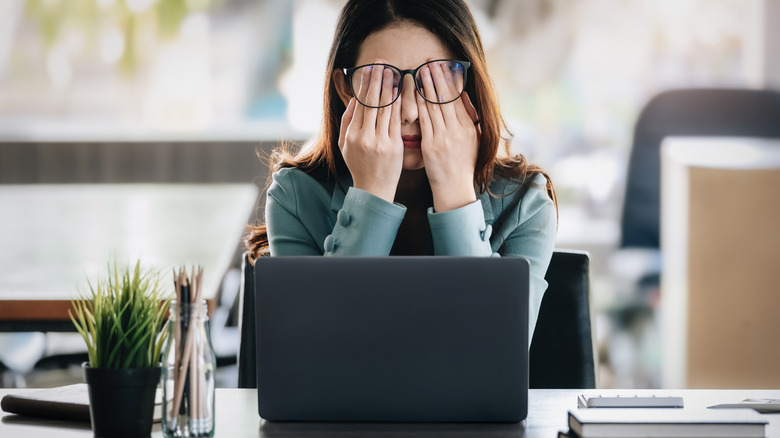 woman feeling burnt out at laptop