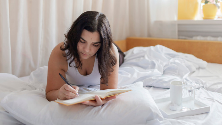 Woman journaling in bed
