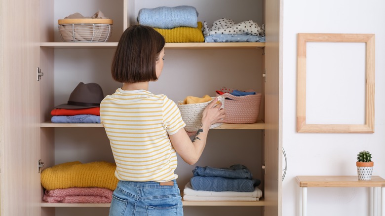 woman organizing clothes in closet