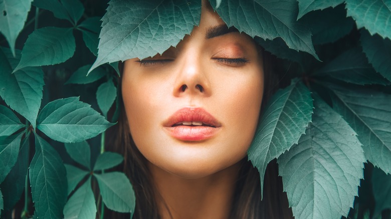 Sleeping woman surrounded by leaves