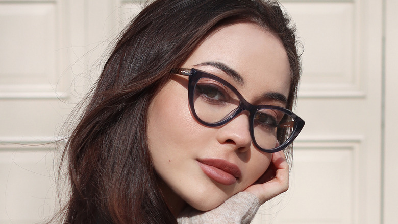 Model wearing black cat-eye glasses