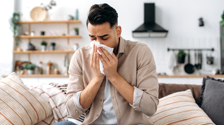 man blowing nose