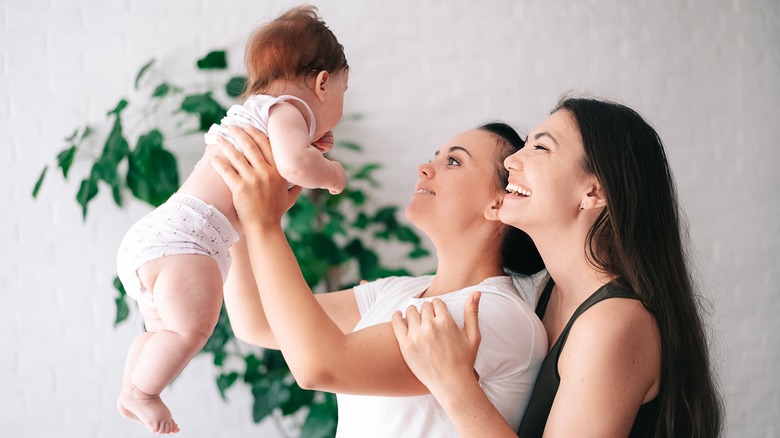 two women smiling at baby 