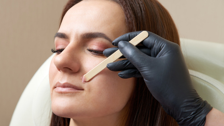 A middle-aged woman having her upper lip waxed