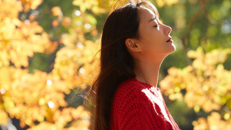 Woman taking deep breaths outside