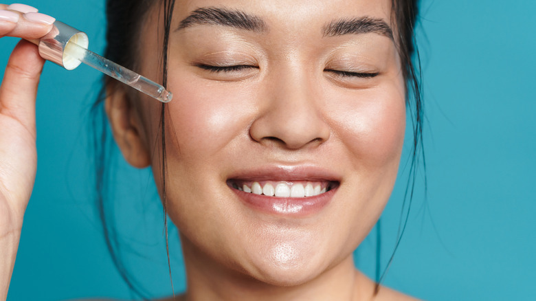 woman applying oil serum