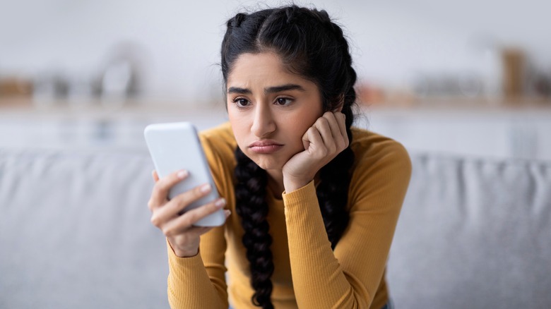 Disappointed woman looking at phone