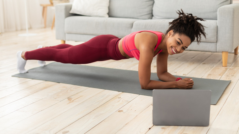 Smiling woman holding plank pose