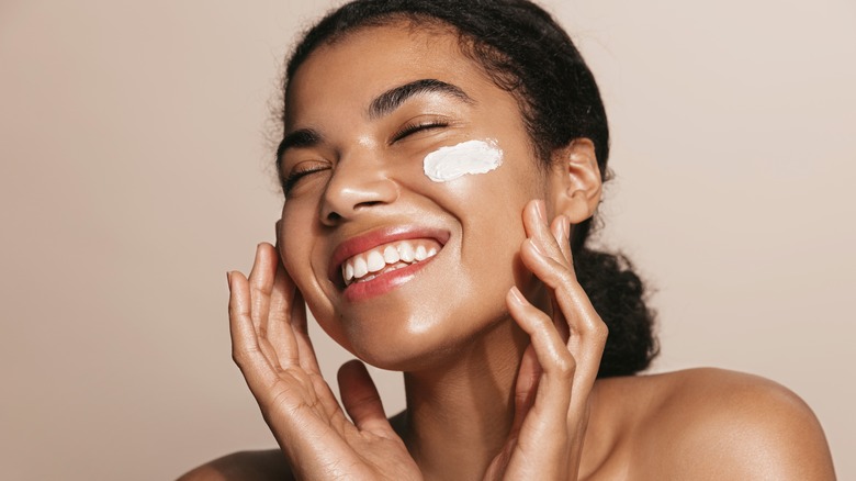 Woman with face cream on her cheeks