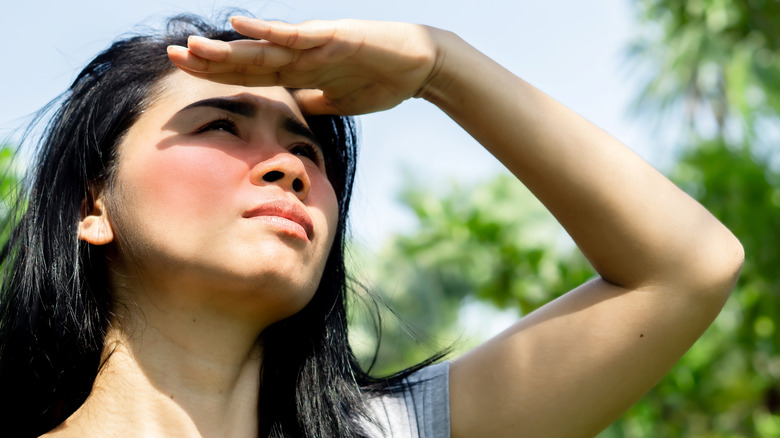 person shielding their face from sun