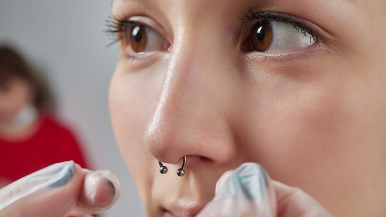 Woman getting her septum piercing