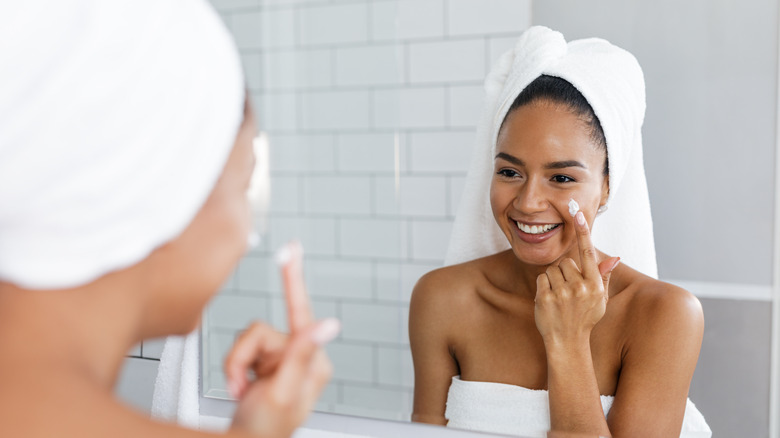 woman applying moisturizer