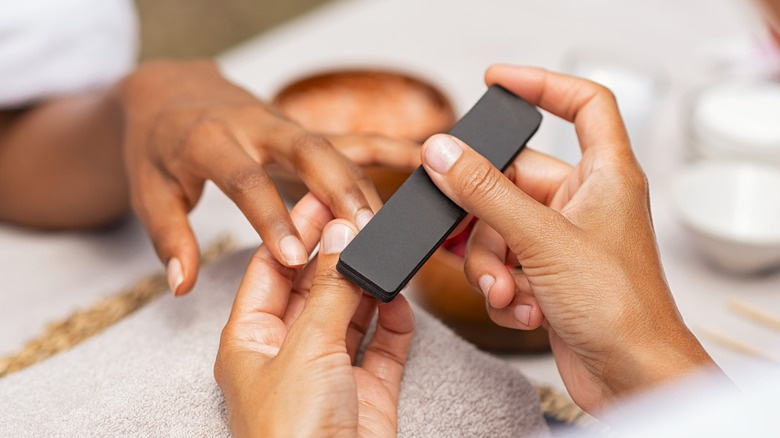 Woman's hands buffing fingernails