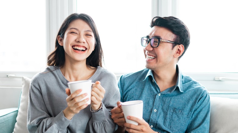 Happy couple holding mugs