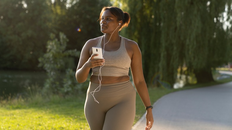 Woman walking outside with earbuds