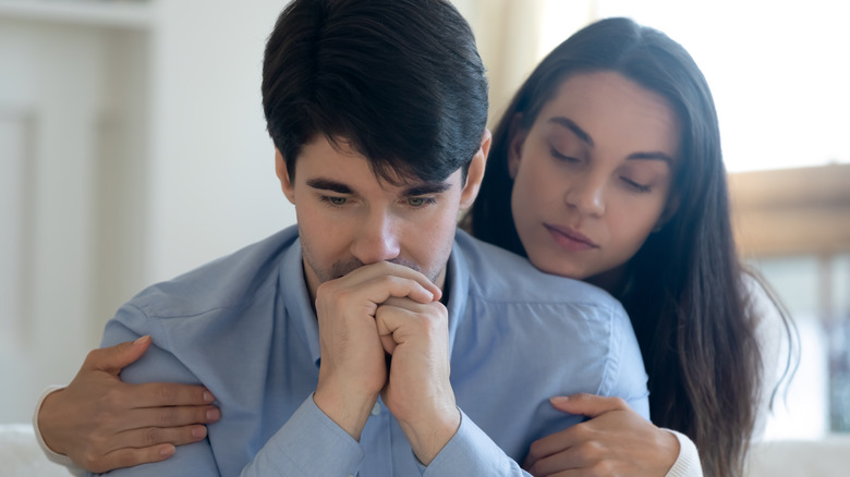 Woman comforting man