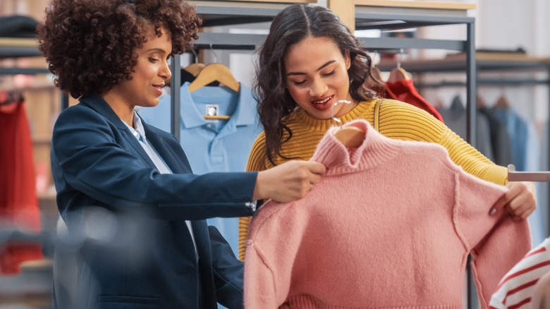 two woman looking sweater