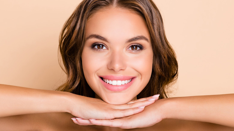 Woman smiling with hands under face