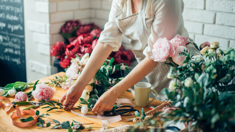 Woman arranging fresh cut flowers