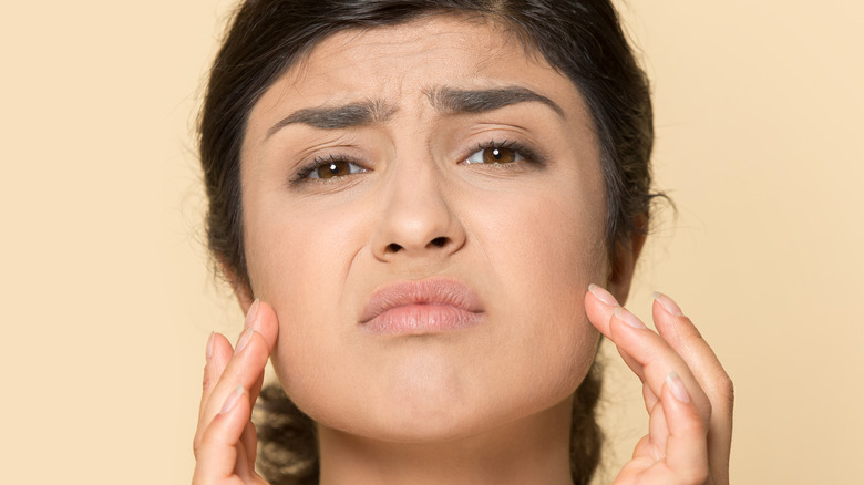 woman unhappy with acne on face