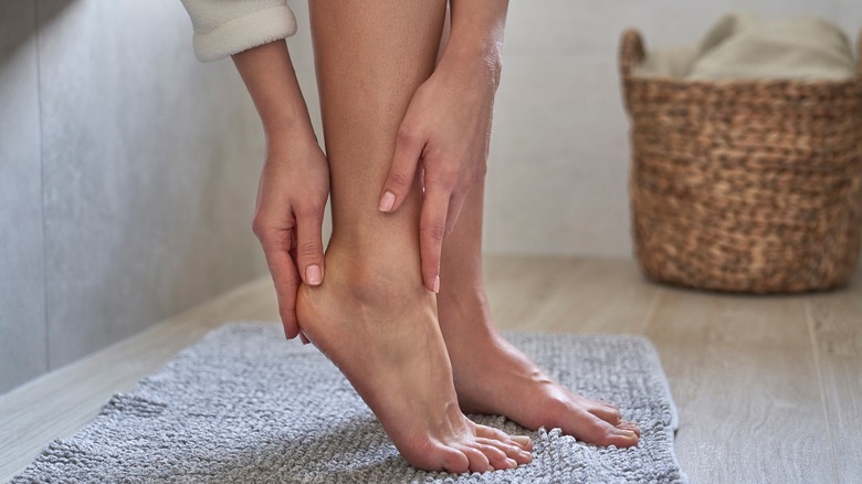 woman massaging cream into heels of feet