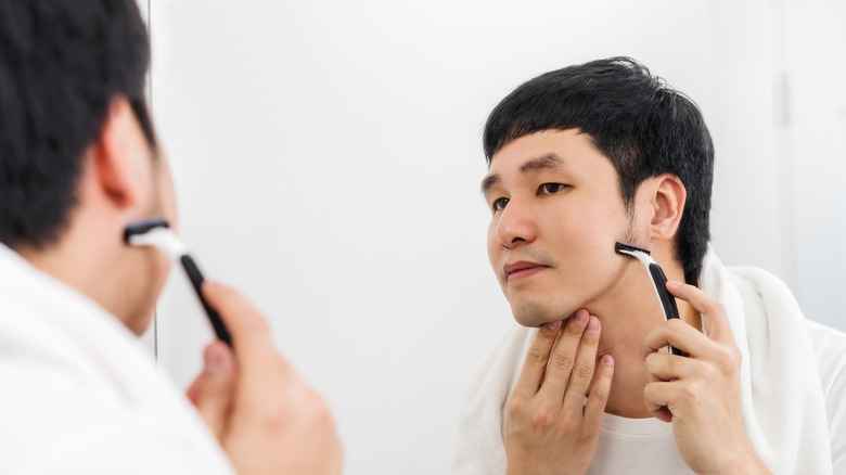 Man touching his face looking in the mirror