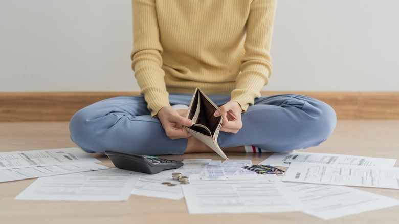 Woman holding empty wallet