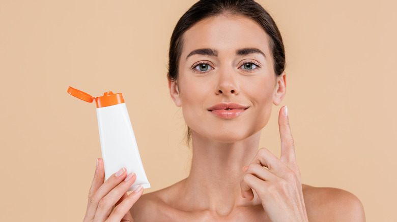 woman applying sunscreen on her face