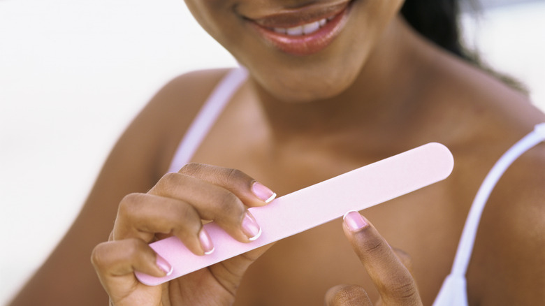woman smiling and filing nails