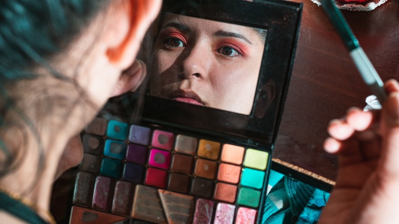 Woman looking at her makeup palette