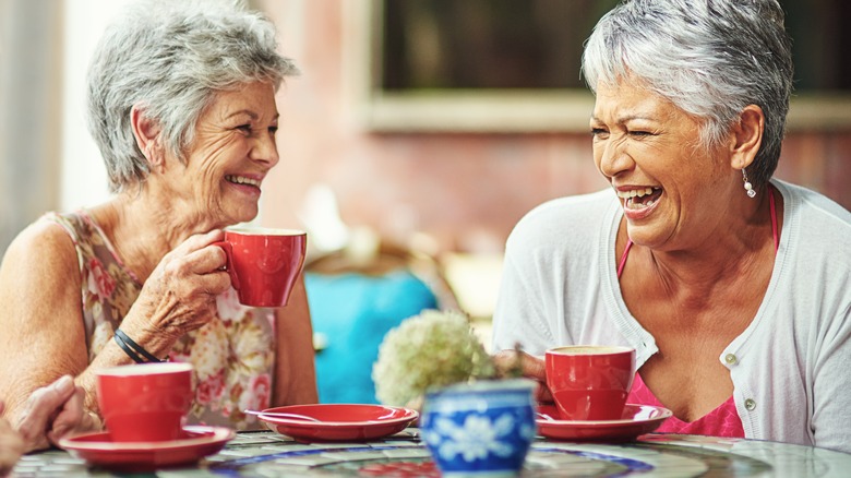 two women laughing over coffee