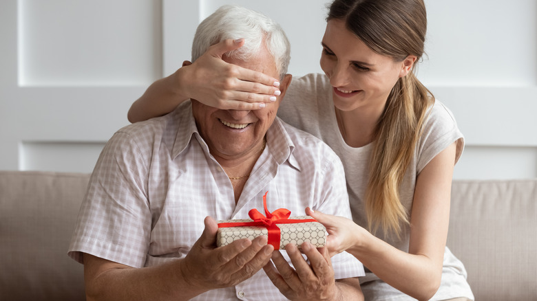 Woman gives gift to older man