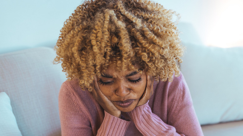 exhausted woman holding face