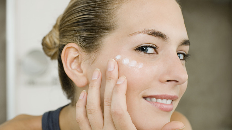 woman applying moisturizer 