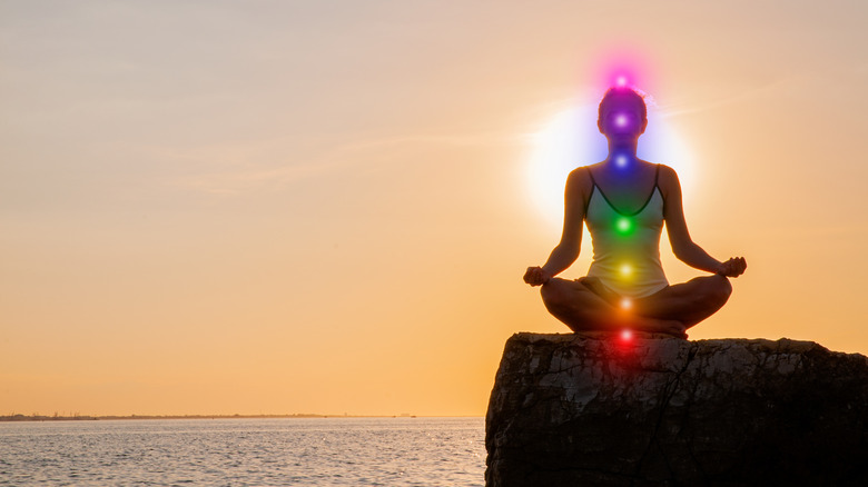 Woman meditating with illuminated chakras