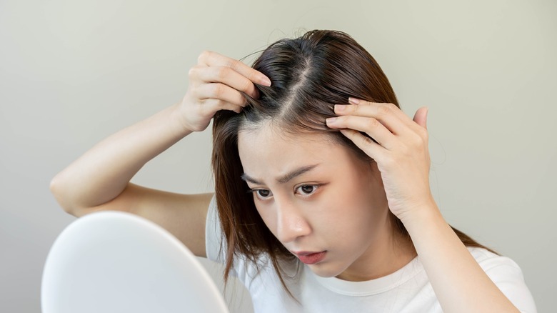 woman examining scalp