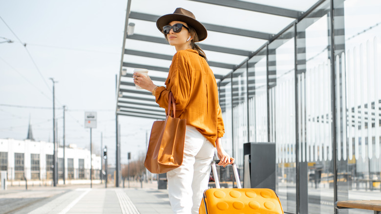 Stylish woman traveling with luggage