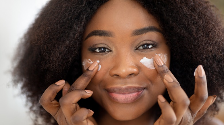 Woman applying moisturizer