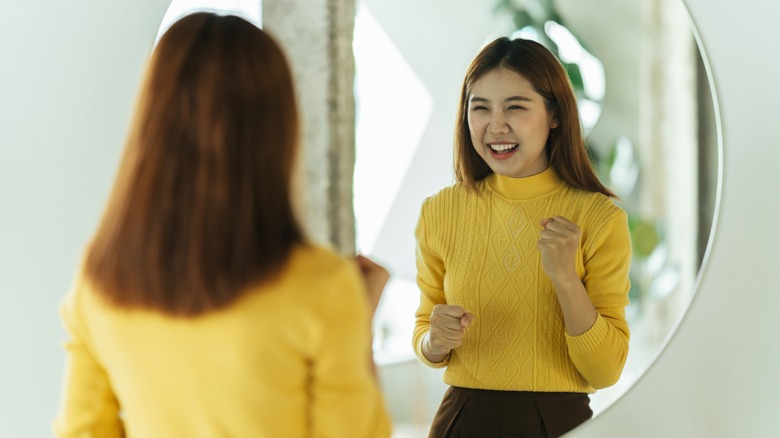 woman practicing self-talk in mirror
