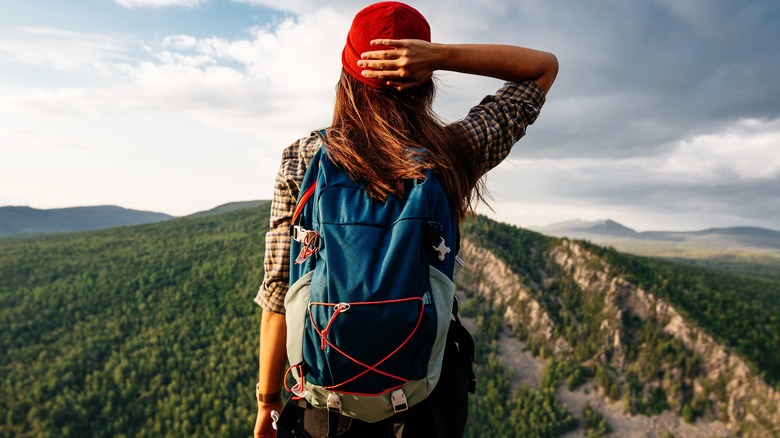 female backpacker looking at hill