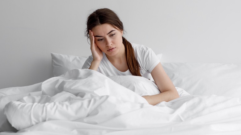 Anxious woman in bed