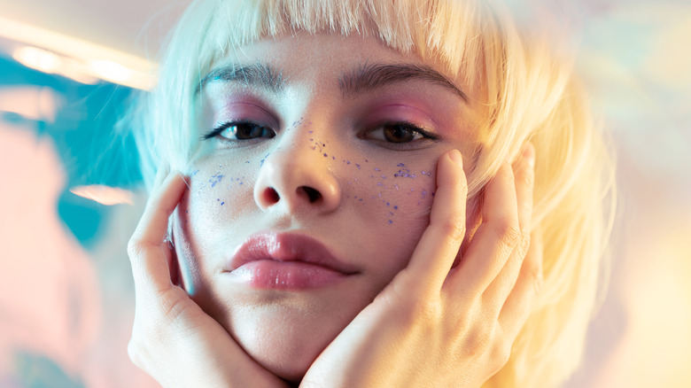 Woman with short bangs and colorful makeup