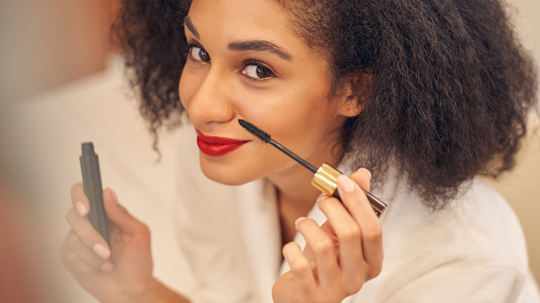 woman putting on mascara