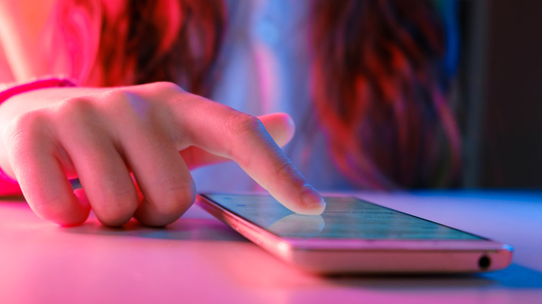 Girl uses iphone with neon lights