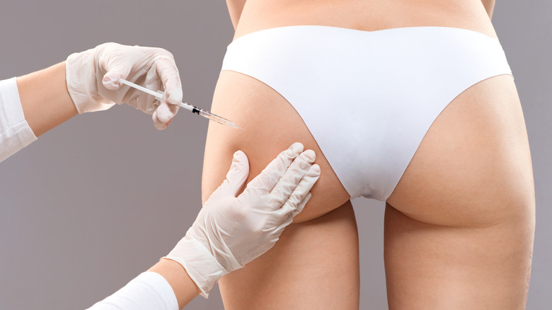 Woman receiving a needle in her butt