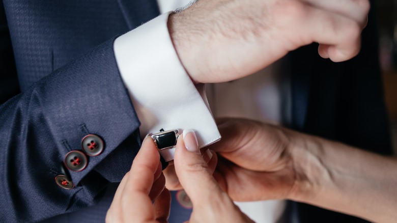 woman fastening partner's cufflink