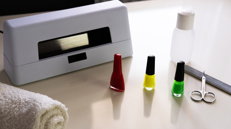 Products needed for a gel manicure, including gel polish and an LED lamp