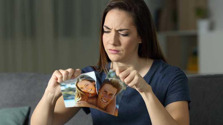 woman tearing couple photo up