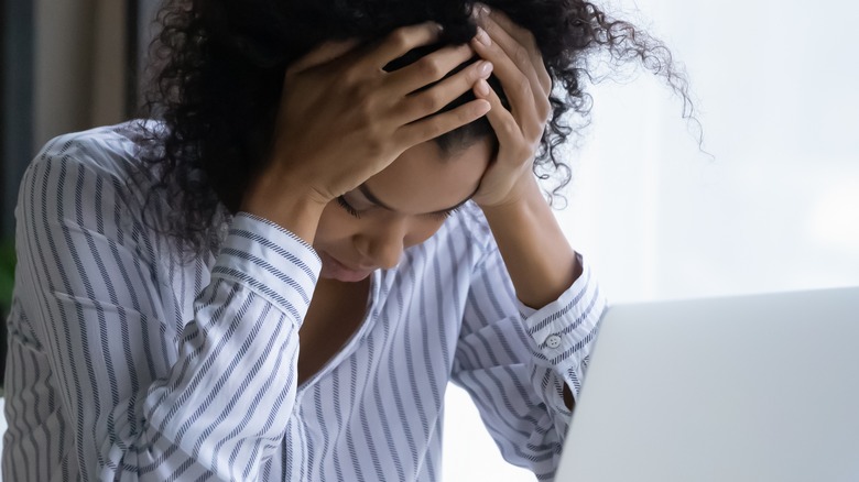 female holding her head frustrated with work 