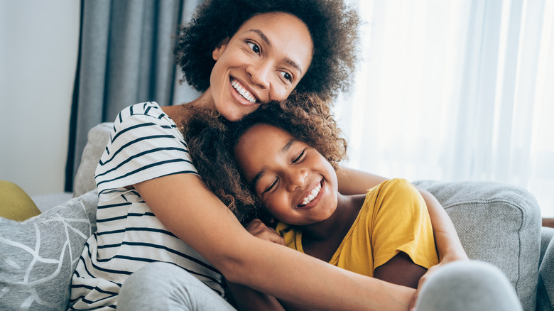 Woman hugging child on couch